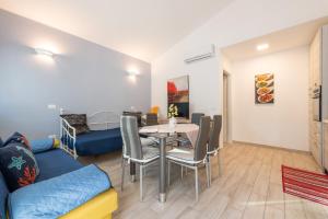 a living room with a table and chairs and a bed at Ibiscus Rosa 1 in Marongiu