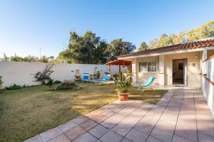 a house with a patio and chairs in the yard at Ibiscus Rosa 1 in Marongiu