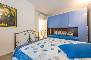 a bedroom with a bed with blue cabinets at Ibiscus Rosa 1 in Marongiu