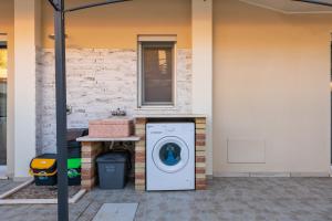 a washing machine sitting outside of a house at Ibiscus Rosa 1 in Marongiu