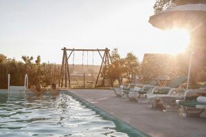 a swimming pool with a roller coaster in the background at Casa das Alfazemas in Cadaval