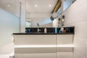 a white kitchen with a sink and a mirror at Landhaus Bleckede - App 1 Bleckede in Bleckede +16 photos