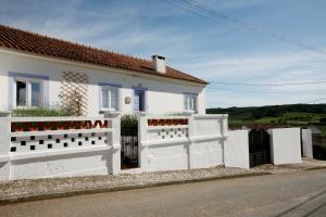 a white house with a white fence in front of it at Casa das Alfazemas in Cadaval