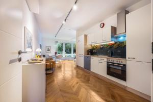 a kitchen with white cabinets and a wooden floor at Landhaus Bleckede - App 1 Bleckede in Bleckede