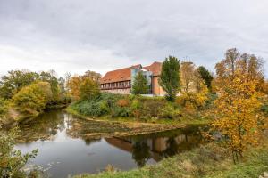 a building on a hill next to a river at Landhaus Bleckede - App 1 Bleckede in Bleckede