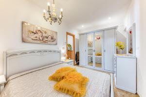a bedroom with a white bed and a chandelier at Il Girasole in Torre Vado