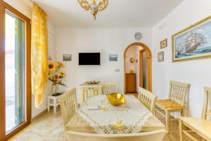 a dining room with a table and chairs and a television at Il Girasole in Torre Vado