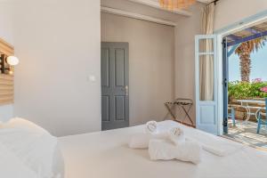 a bedroom with a bed with towels on it at La Casa Tinos 22 in Tinos +149 photos
