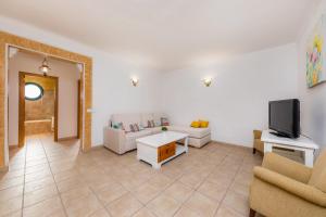 a living room with a couch and a tv at Sa Mina in Santa Margalida