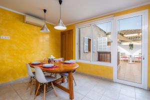 a dining room with a wooden table and chairs at Sa Mina in Santa Margalida