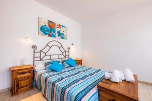 a bedroom with a bed with blue pillows at Sa Mina in Santa Margalida