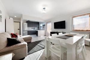 a living room with a white table and a kitchen at La dimora del Lago in Colico