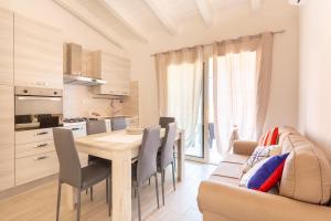 a kitchen and dining room with a table and a couch at Casa Macis vista mare in Isola Rossa