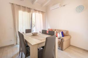 a dining room with a wooden table and chairs at Casa Macis vista mare in Isola Rossa +18 photos