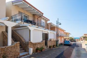 a building with stairs and a balcony on a street at Casa Macis vista mare in Isola Rossa