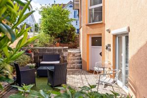 a patio with chairs and a table in front of a building at Ribeiro Tesouro in Friesenheim