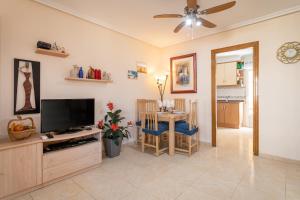 a living room with a flat screen tv and a table at Casa Susan in Torrevieja
