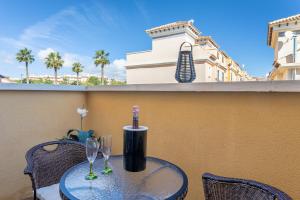 a table with two wine glasses on a balcony at Casa Susan in Torrevieja