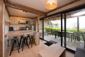 an open kitchen and living room with tables and chairs at Chalet 35m2 - Armen in Plouhinec