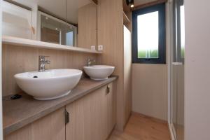 a bathroom with two white sinks on a counter at Chalet 35m2 - Armen in Plouhinec
