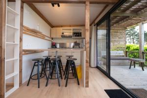 a kitchen with stools and a bar in a house at Chalet 35m2 - Armen in Plouhinec +11 photos