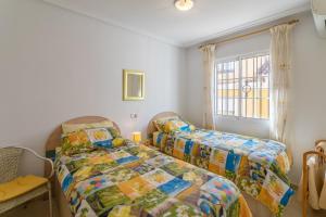 a bedroom with two beds and a window at Casa Susan in Torrevieja +18 photos