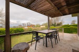 a patio with a table and chairs on a deck at Chalet 35m2 - Armen in Plouhinec