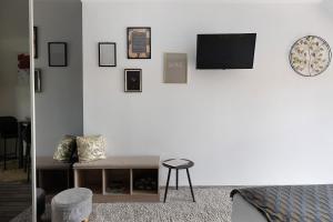 a living room with a couch and a tv on a wall at Chambre D'hôtes Take-off - Chambre in Saint-Georges-sur-Cher