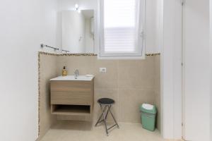 a bathroom with a sink and a stool at Dimora Biscari in Acate +14 photos