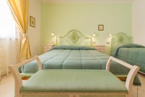 a bedroom with a bed with a bench in it at Il Girasole - Malva in Venturina Terme +27 photos
