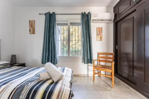 a bedroom with a bed and a chair and a window at Superbly situated Vistamar in Mijas Costa +14 photos