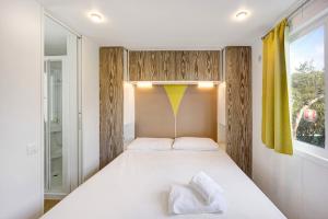 a bedroom with a large white bed with two pillows at Mobile Home Alloro 165 in Pietra Ligure +14 photos