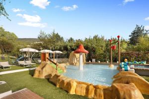 a large pool with a water slide in a backyard at Mobile Home Alloro 165 in Pietra Ligure