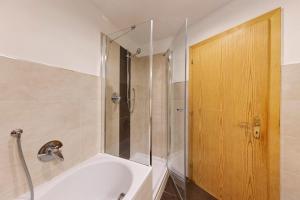 a bathroom with a shower and a white tub at Apartment Bergkristall in Nova Levante +19 photos