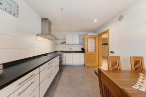 a kitchen with white cabinets and a wooden table at Apartment Bergkristall in Nova Levante