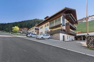 a street with cars parked in front of a building at Apartment Bergkristall in Nova Levante