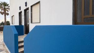 a blue bench in front of a house at Cabo de Sagres -1 bedroom apartment in Sagres