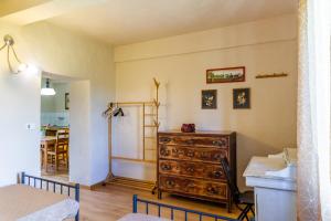 a bedroom with a dresser and a dining room at Appartamento il corso in Roccastrada
