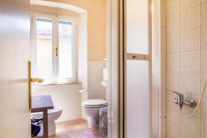 a bathroom with a toilet and a window at Appartamento il corso in Roccastrada