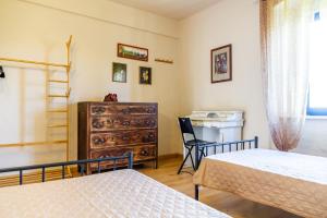 a bedroom with two beds and a dresser at Appartamento il corso in Roccastrada +13 photos