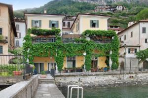 a building covered in ivy next to a body of water at Casa Al Molo in Musso