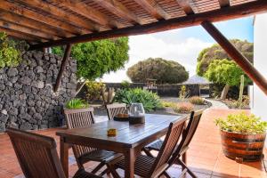 a wooden table and chairs on a patio at Finca La Rubina in Teguise