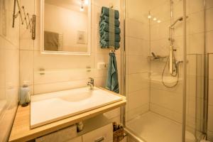 a white bathroom with a sink and a shower at Ferienwohnung Seestern in Norderney +12 photos
