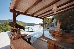 a glass table with a bench on a patio at Villa Lice - Sciacchetrà in Casarza Ligure