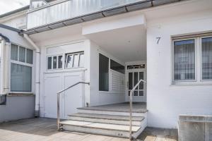 a white house with stairs and a door at Ferienwohnung Seestern in Norderney