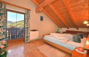 a bedroom with a bed and a large window at Fillerhof in Villnoss