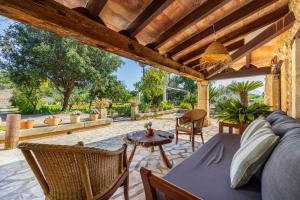 a patio with a couch and a table and chairs at Villa Can Tonet in Port de Pollensa