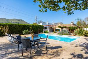a patio with a table and chairs next to a pool at Villa Can Tonet in Port de Pollensa
