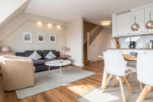a living room and kitchen with a couch and a table at Strandburg in Westerland