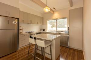 a kitchen with a refrigerator and a table in it at River Vista at Aruma in Walker Flat